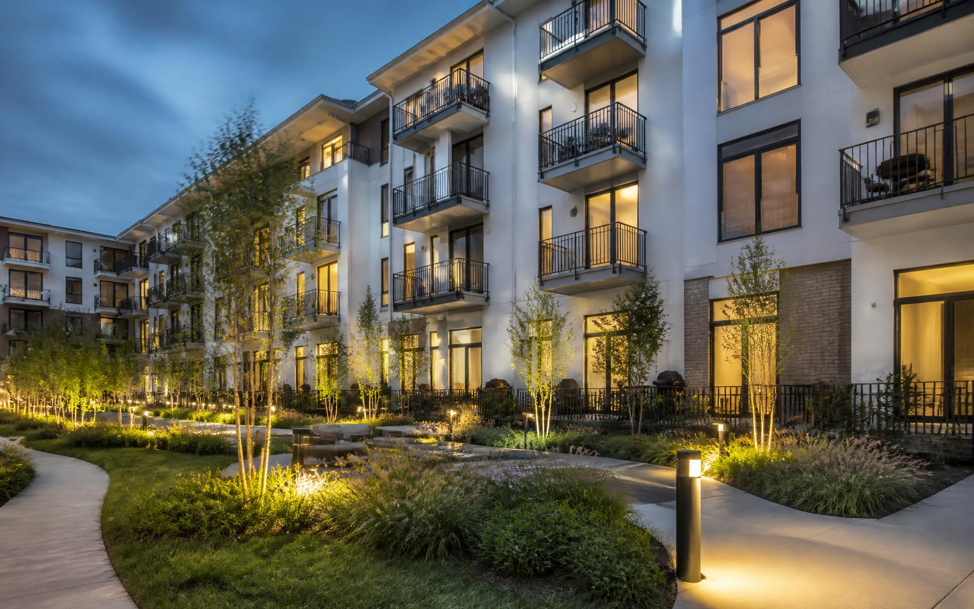 A tree-lined Cotswold street with a mix of housing types